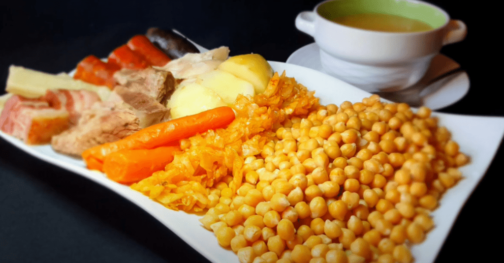 Servicio de catering de cocido madrileño tradicional preparado in situ, con garbanzos, carne, chorizo y verduras frescas para eventos de hasta 400 comensales